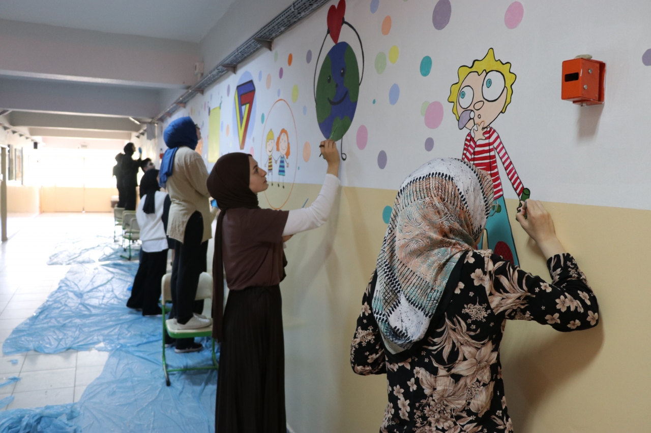 Kütahya'da üniversite öğrencileri ilkokul koridorlarını bilim ve sanat çizimleriyle renklendirdi
